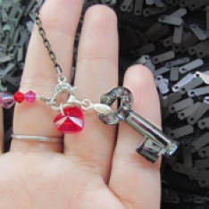 After the charms have been layered, an 8" crystal insert strand (pomegranate, bold style) is connected to the clasp.