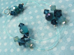 This exclusive, one-of-a-kind insert is designed as an "illusion" style invisible strand. It includes teal blue fishing line and crystals. We may produce this strand in the furture, although it has an unfortunate tendency to kink permanently when worn often. Our other designs do not have this issue.